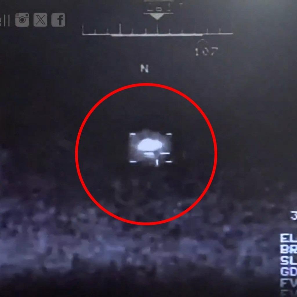 A dark infrared image of an unidentified flying object, circled in red, with navigational readouts around it.